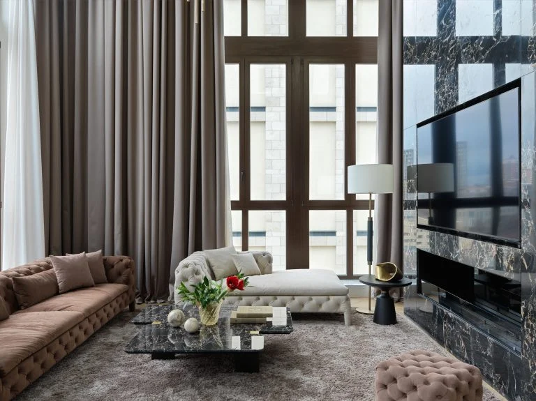 Phòng khách Penthouse Gia Lâm với cửa kính cao, rèm dài và mảng tường tivi vân đá