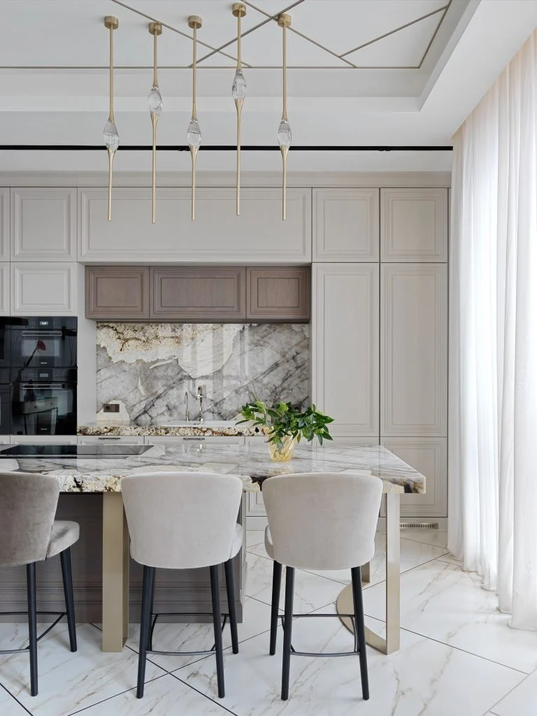 Bếp Penthouse Gia Lâm với hệ tủ sáng màu, đảo đá và ghế ăn bọc nệm