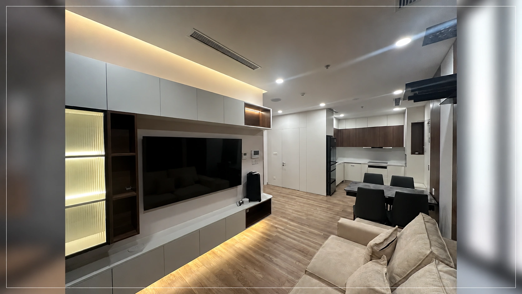 Góc nhìn từ sofa về kệ tivi, tủ trưng bày có đèn và bàn ăn
