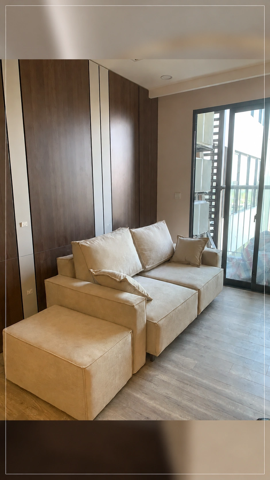 Chi tiết sofa màu kem, gối tựa và đôn rời trong phòng khách