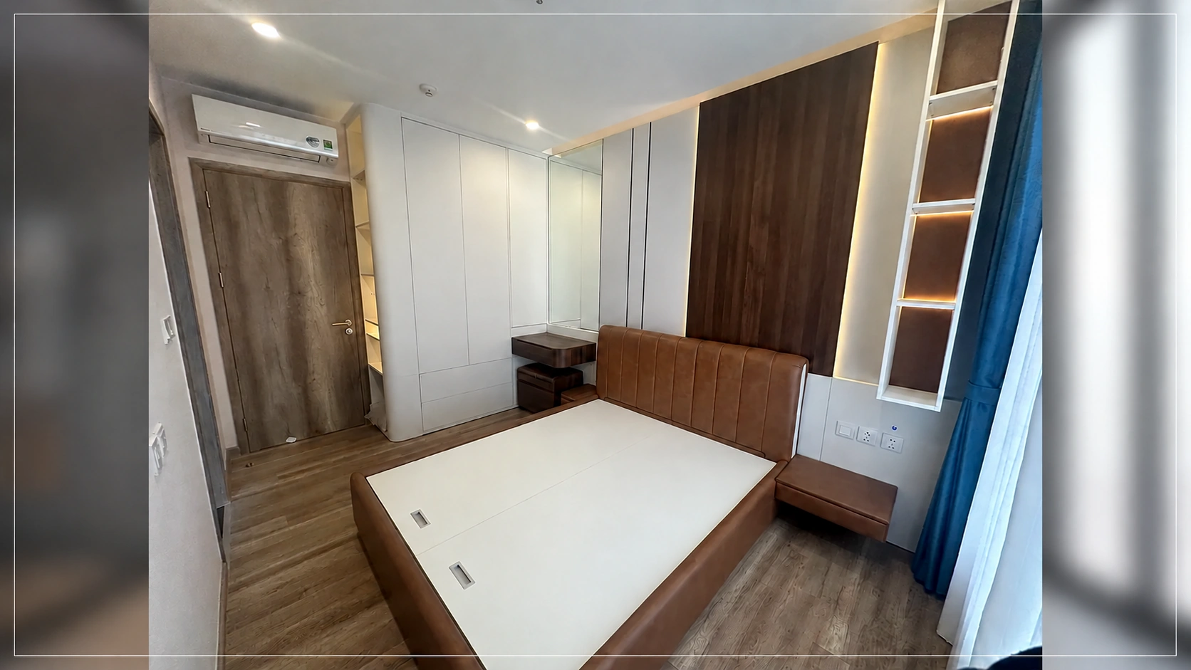 Giường ngủ, vách đầu giường có đèn và tủ áo trong phòng ngủ chính