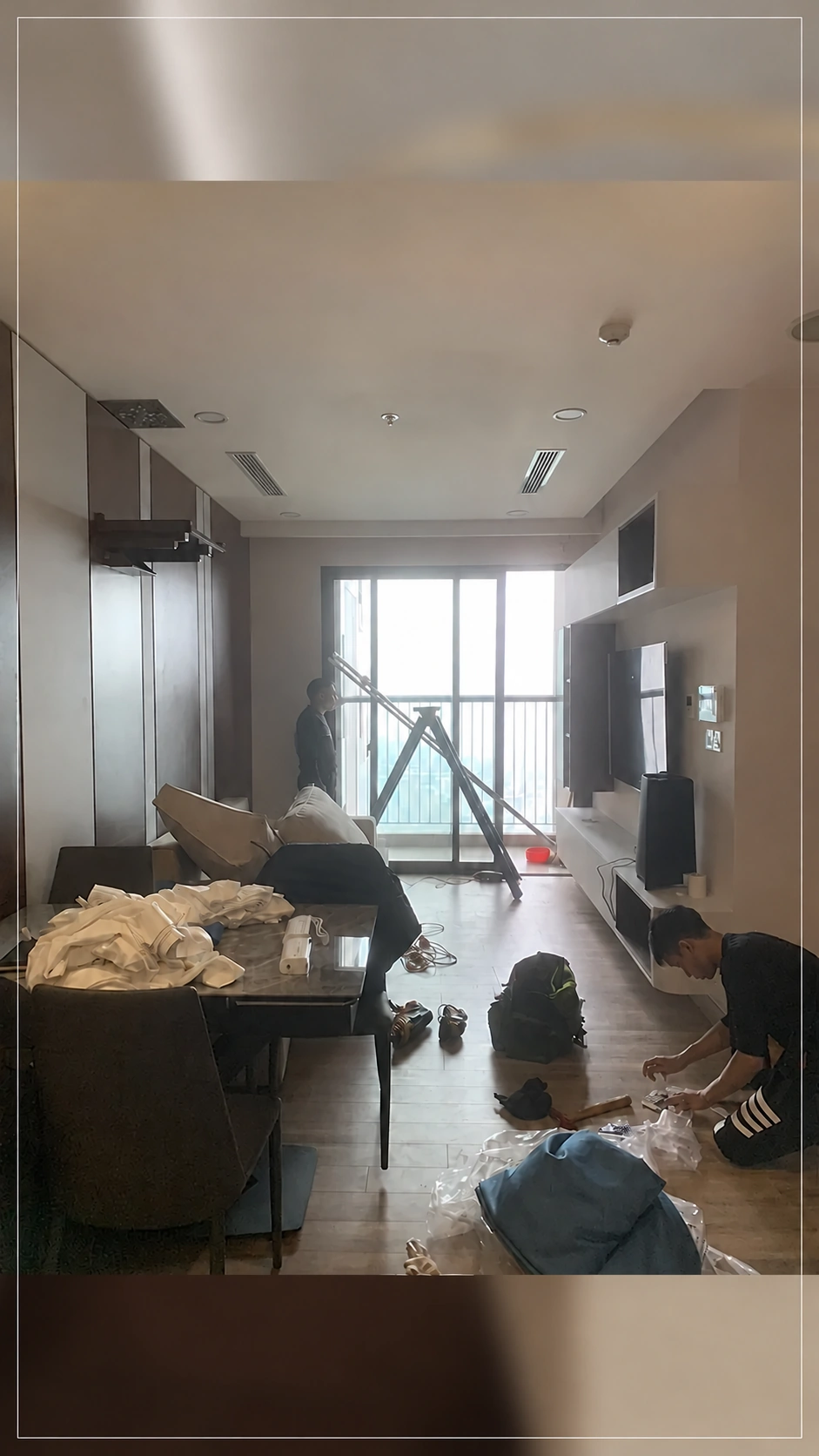 Góc phòng khách trong quá trình lắp rèm với thang và phụ kiện trên sàn