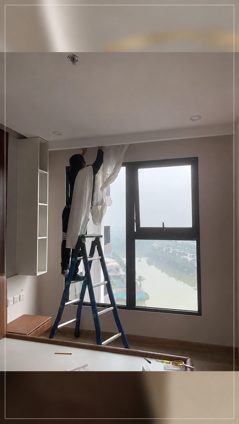 Thợ treo voan trắng tại cửa sổ phòng ngủ
